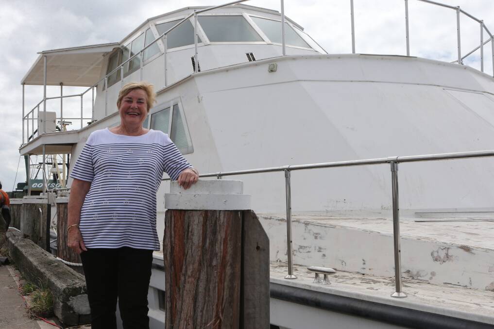 Former owner Bev Bloomfield proudly stands along side the catamaran at the Greenwell Point main wharf.