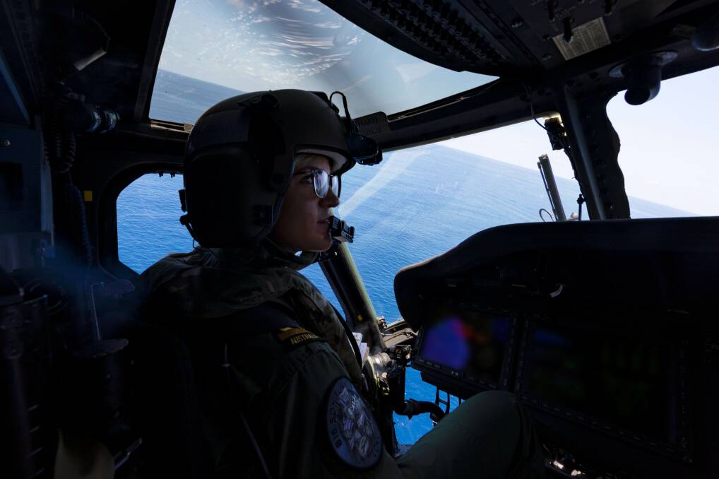 IN THE HOT SEAT: Maritime Aviation Warfare Officer, Sub-Lieutenant Ashley Hill, on the MRH-60 helicopter, callsign 'Convict', embarked on HMAS Ballarat for Exercise Malabar. Photo: Shane Cameron
