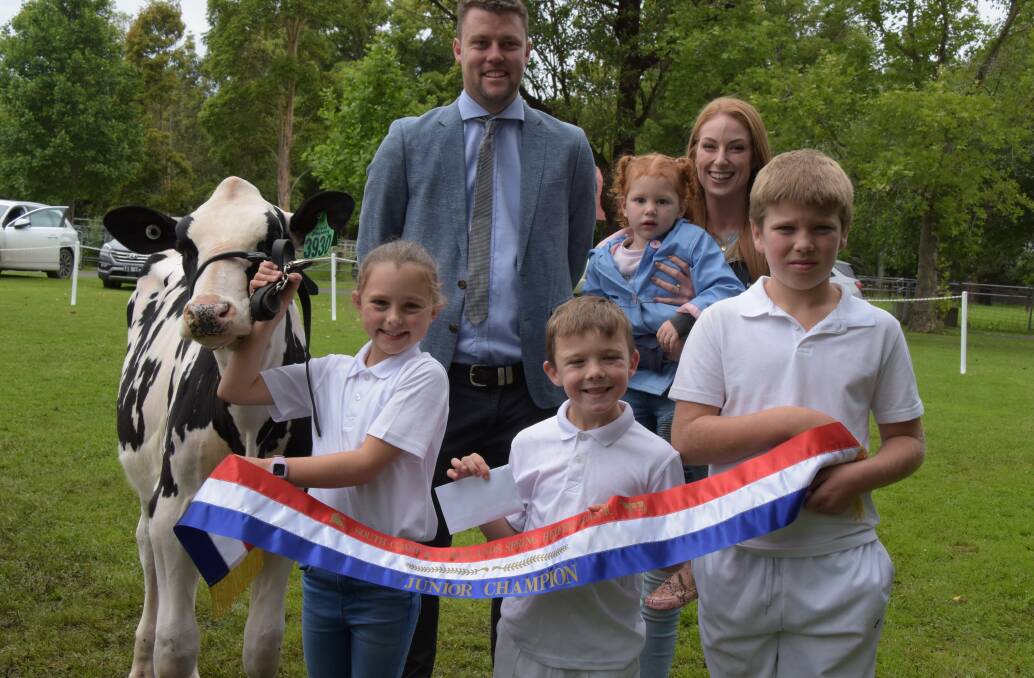 JUNIOR CHAMPION: Waljasper Freddy Lola, entered by the Walsh Family and exhibited by Ella Walsh claimed the junior champion ribbon at the South Coast and Tablelands Holstein Association Spring Heifer Classic. Judge Daniel Bacon and Emma and Bella Cochrane, of Raine and Horne Nowra present the ribbon to Ella and her cousins Sam and Cooper Green.