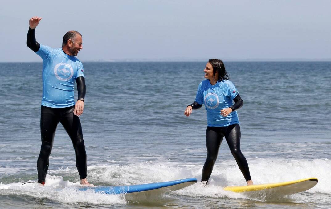 UNREAL: Graeme Copeland and Tahnee Barnes catch a wave as part of the veteran Surf Program.: Photo: Levi Cahill