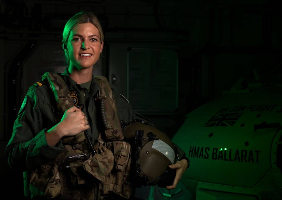 READ TO GO: Maritime Aviation Warfare Officer, Sub-Lieutenant Ashley Hill, stands in front of the MRH-60 helicopter, callsign 'Convict', embarked on HMAS Ballarat for Exercise Malabar. Photo: Shane Cameron