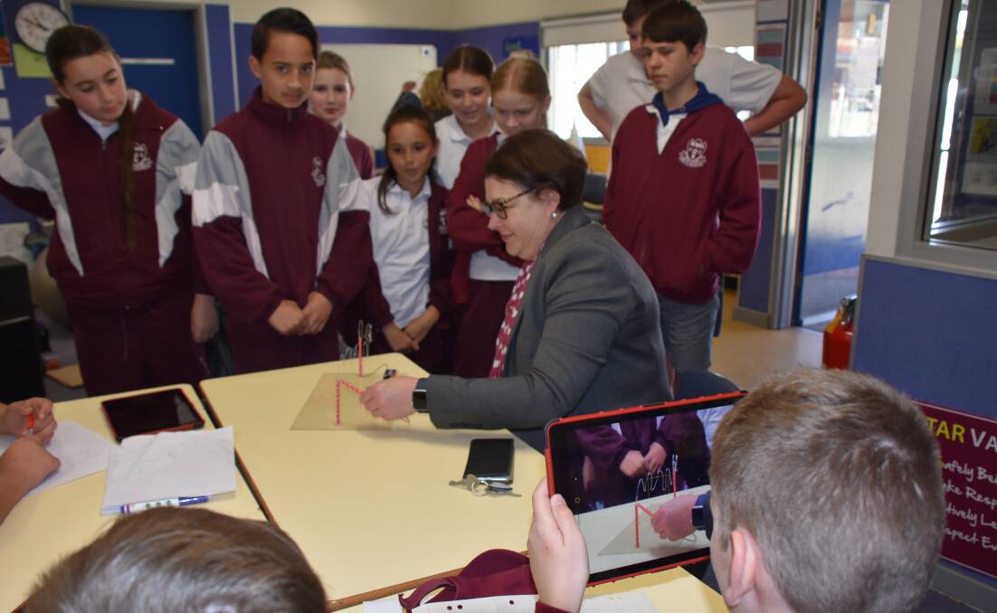 Nowra Public students use an iPad to film principal Nicole Humphreys undertaking one of the year 6 class experiments.
