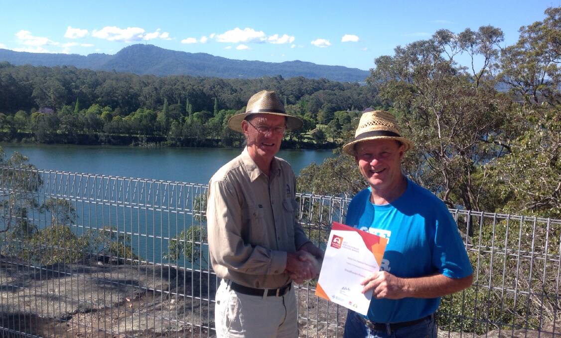 Shoalhaven Landcare chairperson Greg Thompson presents Shoalhaven Riverwatch president Peter Hanson with the NSW Landcare Fish Habitat Innovation Award.