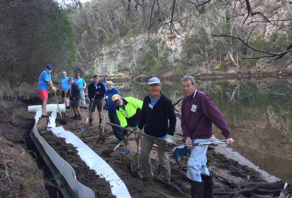Shoalhaven Riverwatch volunteers Ed Tap, Grant White, John Miskelly, Len White, Peter Rodden, Raymond Martin, Ros Christie, Tony Innis, Peter Jirgens and Ian Bice constructing the sand sausage at Yowaka River, Pambula.