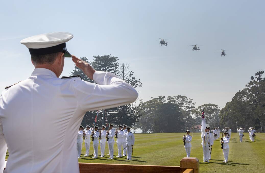  The reviewing officer of the new entry officers course graduation parade, Deputy Chief of Navy, Rear Admiral Mark Hammond takes the salute as three of the Royal Australian Navy's EC-135 Helicopters from 723 Squadron conduct a flyover of the parade ground at HMAS Creswell. Photo: Cameron Martin
