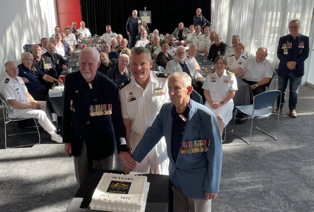 GATHERING: Bob Brown (left) and Rusty Marquis cut a special 50th anniversary cake, with the RAN's latest Warrant Officer Royce De Strang.