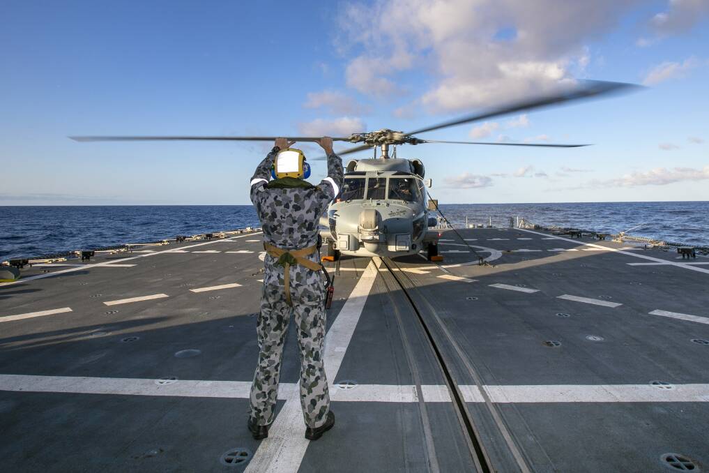 READY TO GO: An 816 Squadron MH-60R helicopter from HMAS Albatross, on the flight deck of HMAS Hobart, during Exercise Rim of the Pacific 2020. Photo: Ernesto Sanchez