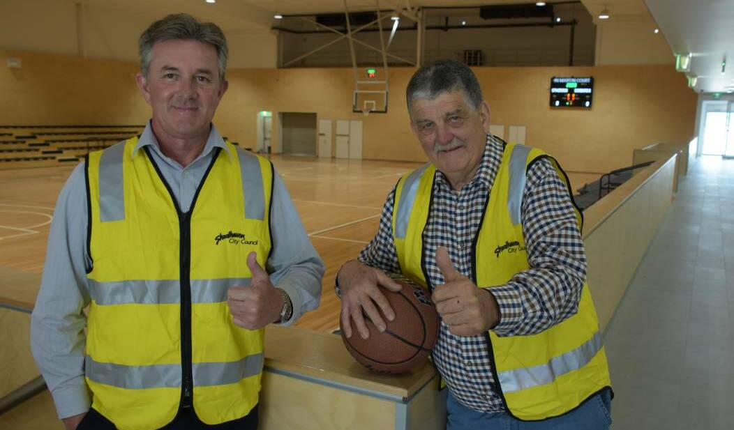 FLASHBACK: Shoalhaven City Council's Shoalhaven Indoor Sports Centre project manager Gary George (left) with local basketball legend John Martin and the show court centre piece that has been named in his honour just prior to the complex hosting its first events in October 2019.