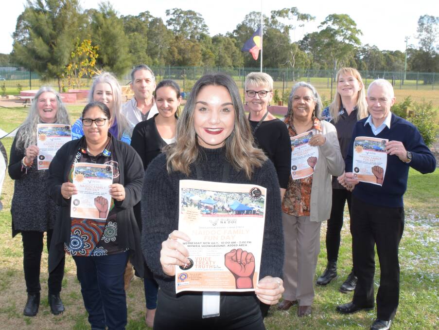 Shoalhaven NAIDOC Committee member Janaya Hennessy proudly shows off this year's Shoalhaven NAIDOC Family Fun Day poster with fellow committee members (from left) Joani Braham, Tara Leslie, Amy Smith, Mark Milbrya, Jasmine Deaves, Donna Corbyn, Aunty Pat Seymour, Kath Vangelovski and Tony Allen.