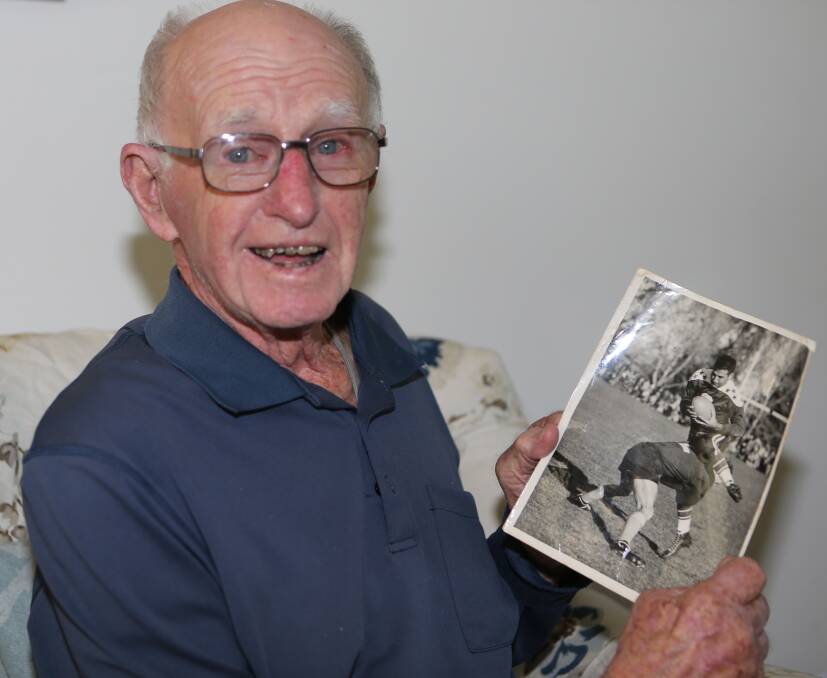 One of the oldest surviving Pyree Rovers players Greg Watts with a photo of him tackling his opposite number Ed Demirjian while playing for Southern Districts against the touring American All Stars at Manuka Oval in Canberra on Wednesday, May 27, 1953. 