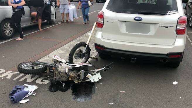 The aftermath of the crash in Woolworths Nowra car park, with the trail bike snapped in two.
