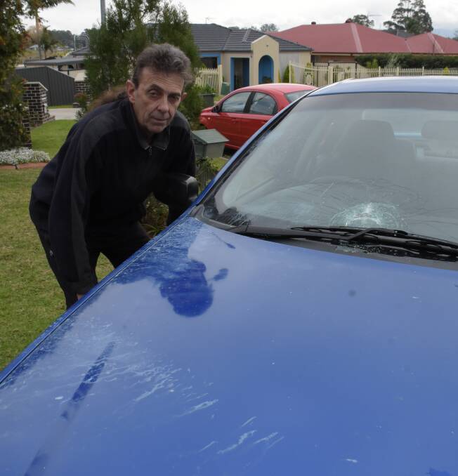 DAMAGE: Nowra man Brad Reeves with one of the damage cars from Wednesday night's pipe bomb attack.
