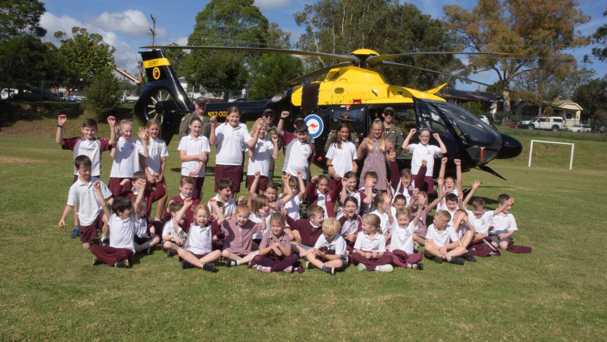 GREAT VISIT: Nowra Public School students whose parents are defence personnel and Principal Nicole Humphreys pose with the aircrew for a special photograph in front of the helicopter.
