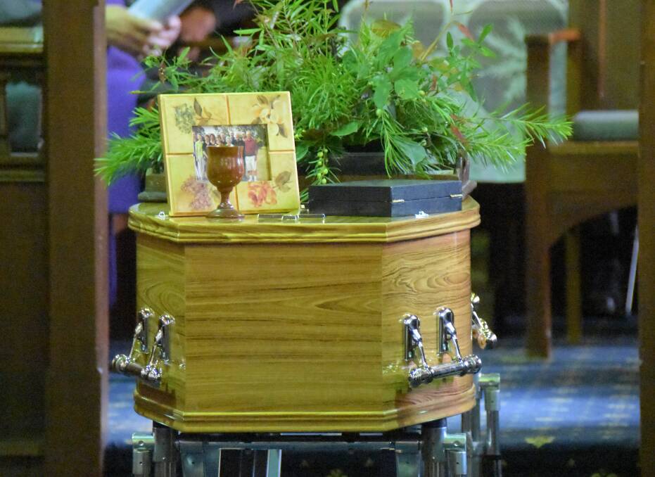 Ian McKinnon's coffin adorned with some gum leaves from his beloved bush at Tomerong, Falls Creek and Nowra, his various medals of recogition including his OAM, a cedar goblet he turned and most importantly a photo of his family, which was the centre of his life.
