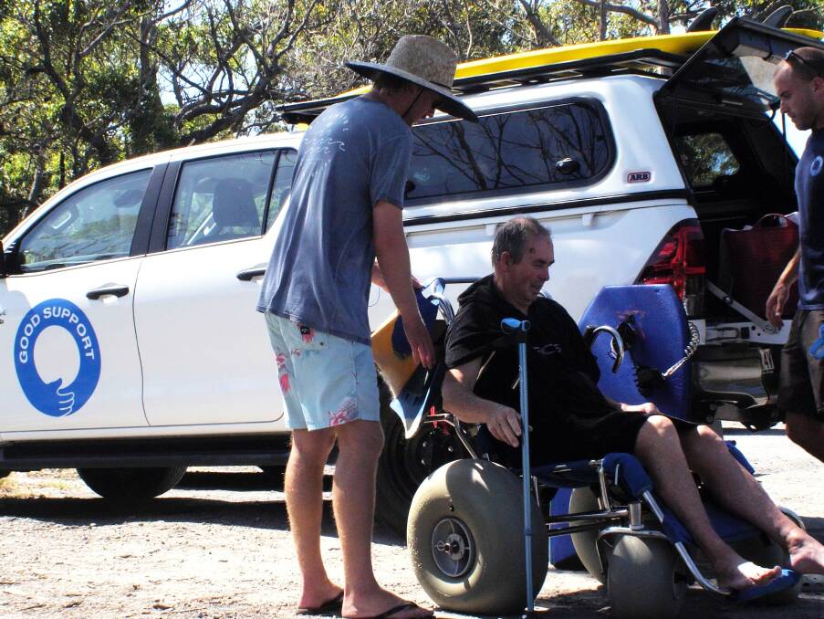 MAKE IT EASY: Russ Quinn (left) and James Gissing use a beach wheelchair to get Steve Preston and their gear to the beach. Image: James Kates