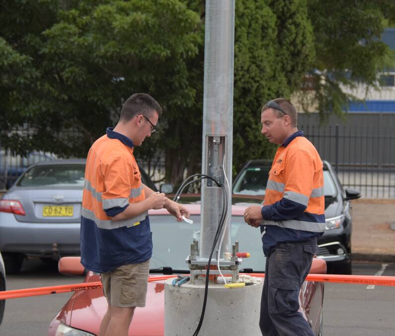  Local contractors from IJED Electrical and Data installing one of eight new 200W LED lights in the Collins Way / Osborne Street car park in Nowra CBD.