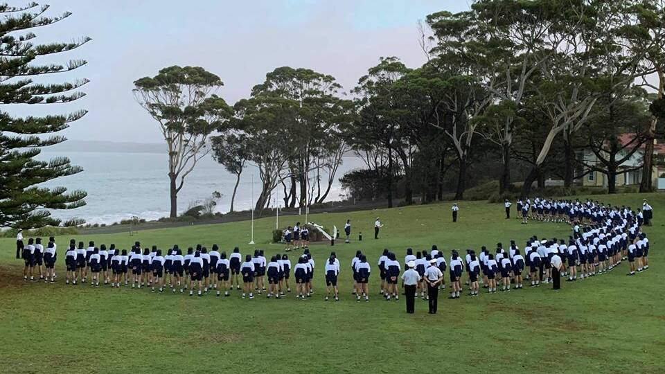 Staff and the new entry officers' course at HMAS Creswell marked the 56th Voyager anniversary with an early morning service overlooking Jervis Bay. Photo: Amy Vickers.
