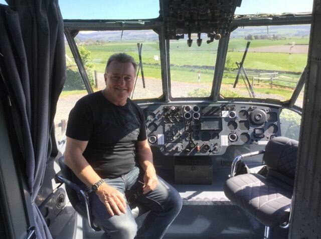 Rick Meehan sitting in the cockpit of the former Royal Navy Sea King now converted into a bar area in the glamping pod.
