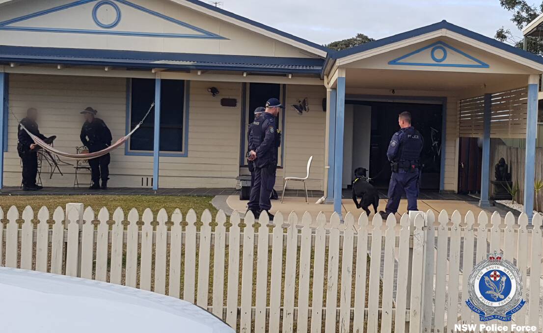 Officers from Strike Force Adnamira and Strike Force Raptor raid the Culburra Beach home. Photo: NSW Police Media