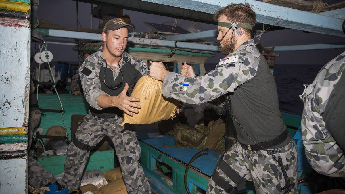 HMAS Warramunga Boarding Party members, Able Seaman Communication and Information Systems Jacob Dun (right) from Nowra and Able Seaman Combat Systems Operator Corey Bartlett relocate parcels of seized narcotics during the ship’s deployment on Operation Manitou. Photo: Tim Gibson