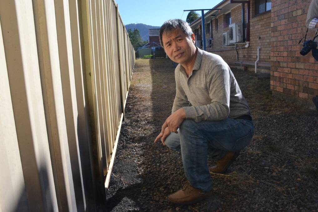 Motel operator James Lin shows where Wednesday’s West Cambewarra Road North Nowra fire lapped under the fence at the rear of the Bomaderry Motor Inn.