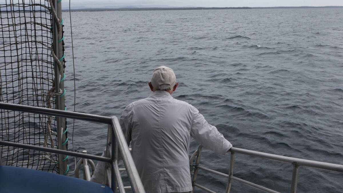 SOLEMN MOMENT: Former Royal Navy pilot David Eagles takes a moment on Jervis Bay to remember fellow flyers, Arthur Arundel and Noel Fogarty, who died after a mid-air collision after exercises over the Bay in 1956.