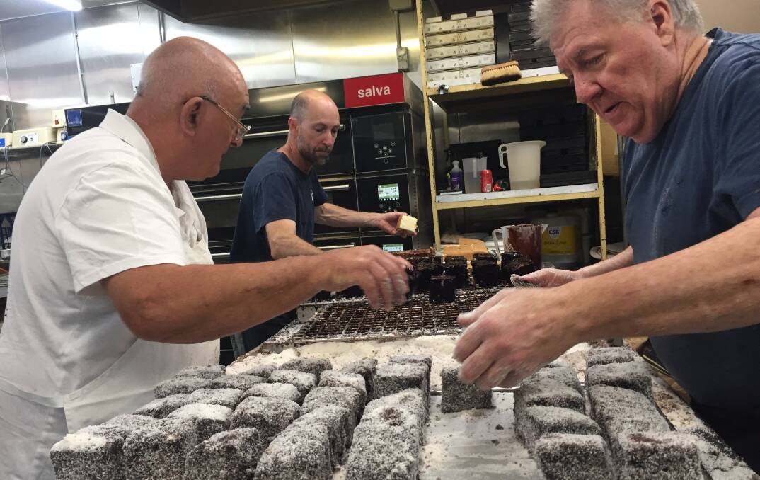 ANOTHER DOZEN DOWN: Vic Leng, Pete Satchell and Garry Moon from the Bakehouse Delights put the finishing touches on anotrher bnatch of lamingtons to support Harvey.