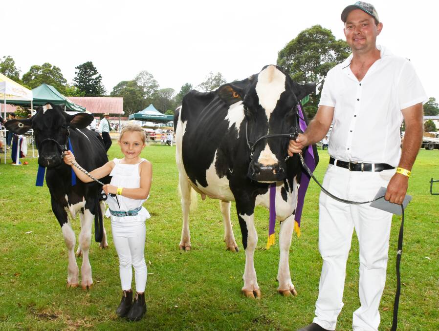 Like father like daughter: Ella Walsh proudly shows off her junior paraders’ first place ribbon with Waljasper King Doc Suzette and her dad Justin who claimed supreme champion cow with Juleanwes Windy Dita.