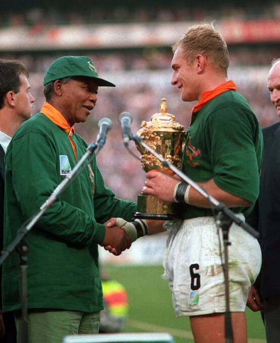 SPECIAL MOMENT: Colin was there in South Africa capturing the action in 1995 when Nelson Mandela presented Springbok captain Francois Pienaar with the Webb Ellis Cup.