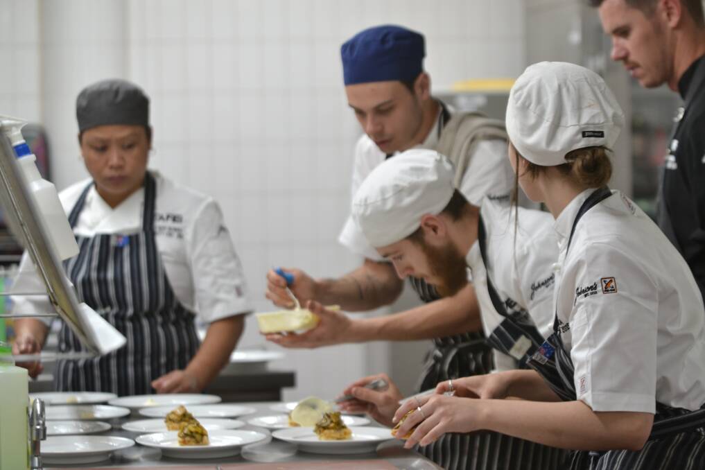Celebrity chef Chris Thornton (far right) oversees the apprentice chefs at this week's Nowra degustation dinner.
