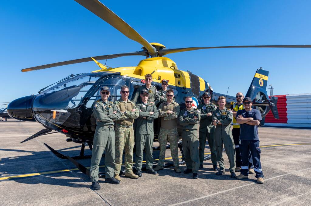  Executive Officer 723 Squadron Lieutenant Commander Gavin Johnston (left) with the unit's detachment flight during the 2019 NSW Bushfires at RAAF Base Williamtown. Photo: Shane Cameron
