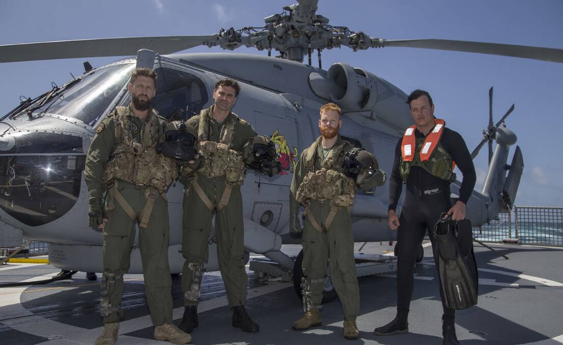 NAVY ROLE: Leading Seaman Aircrew Liam Carruthers (far right) in his day job in front of the MH-60R helicopter on the flight deck with Petty Officer Aircrew Chris Hodgkinson, Lieutenant John Flynn and Lieutenant Ben Thomson. Photo: Richard Cordell