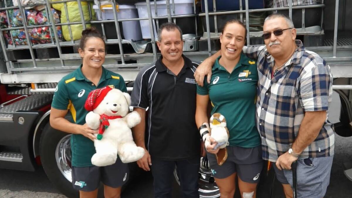 HELPING HAND: Proud Shoalhaven grandfather Ian Pig Usher (far right) with his granddaughter Rhiannon Byers (second from right) and fellow Australian womens sevens rugby team member Shannon Parry and Damien Radburn from local firm Kerden Haulage make their delivery to Nerriga.