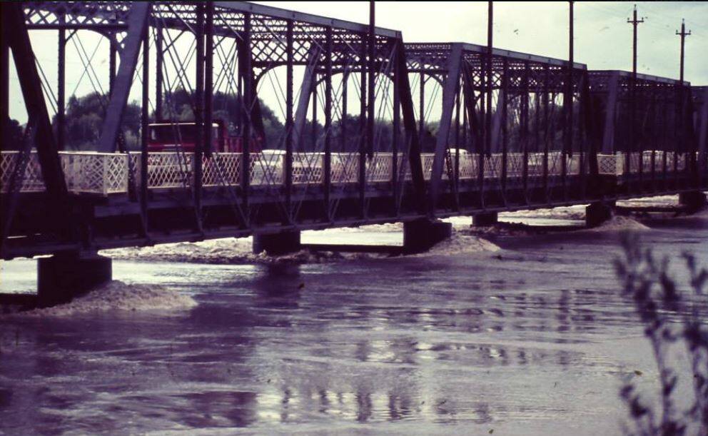 Floodwaters lap at the bottom of the old iron Nowra bridge in the 1974 flood. Photo: Shoalhaven Historical Society.
