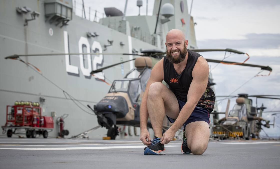 READY TO GO: Royal Australian Navy sailor, Leading Seaman Aviation Technician Avionics Scott Tunnard prepares to run on the flight deck of HMAS Canberra during Regional Presence Deployment 2020. Photo: Tom Gibson