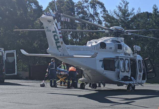 The injured woman being transferred from an ambulance to the Toll NSW Ambulance Rescue Helicopter at the Log Cabin, Tomerong. Photo: Stuart Thomson