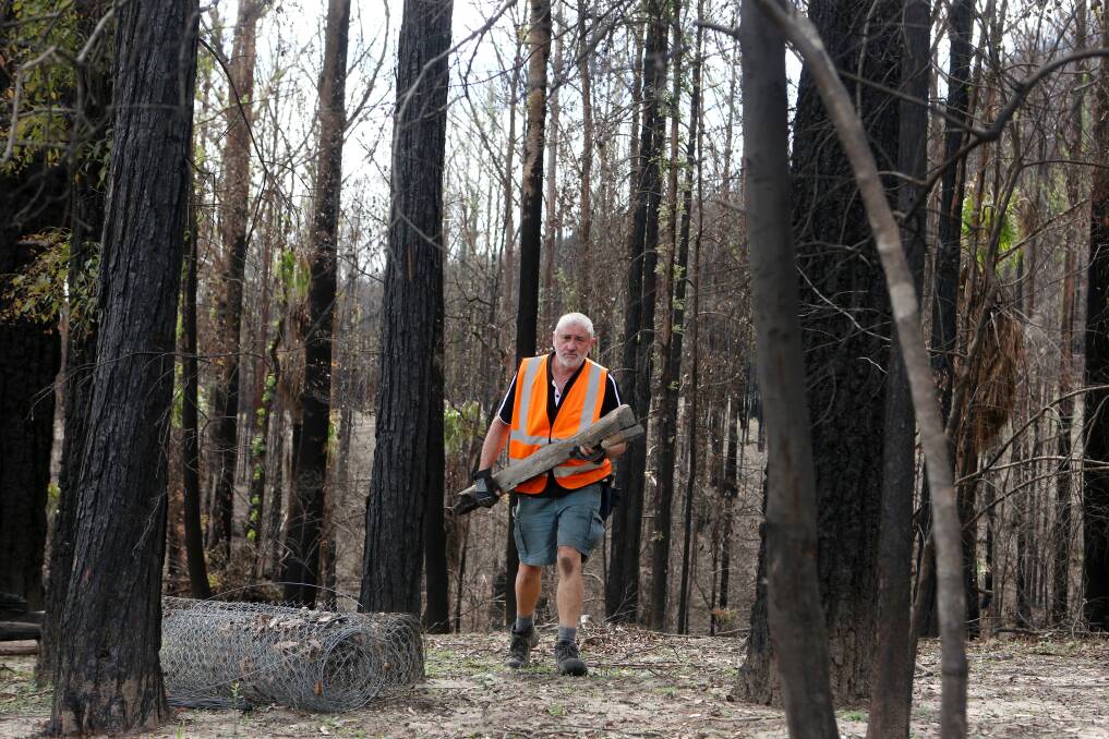 HARD AT IT: BlazeAid volunteer Greg Murphy cleaning up a Kangaroo Valley property. His past emergency services experience has been a huge boost for the organisation. Photo: Sylvia Liber