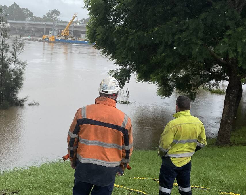 ON ALERT: Fulton Hogan work crews keep a watchful eye on the barge used in the new Shoalhaven River bridge project, during the ongoing flood emergemncy.