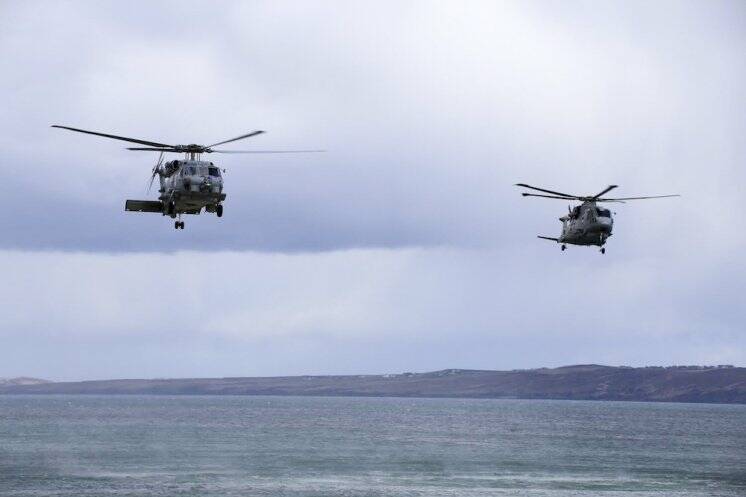 A RAN MH-60R Seahawk helicopter from 816 Squadron at HMAS Albatross (left) and and a Royal Navy Merlin helicopter from 820 Squadron fly low over the Scottish coastline during Exercise Joint Warrior 18.