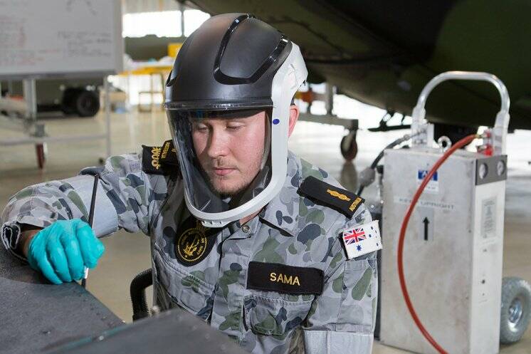 Able Seaman Mitchell Sama utilises the Positive Air Breathing Apparatus while conducting maintenance on an MRH-90 Taipan Multi Role Helicopter at 808 Squadron at HMAS Albatross. Photo: Justin Brown