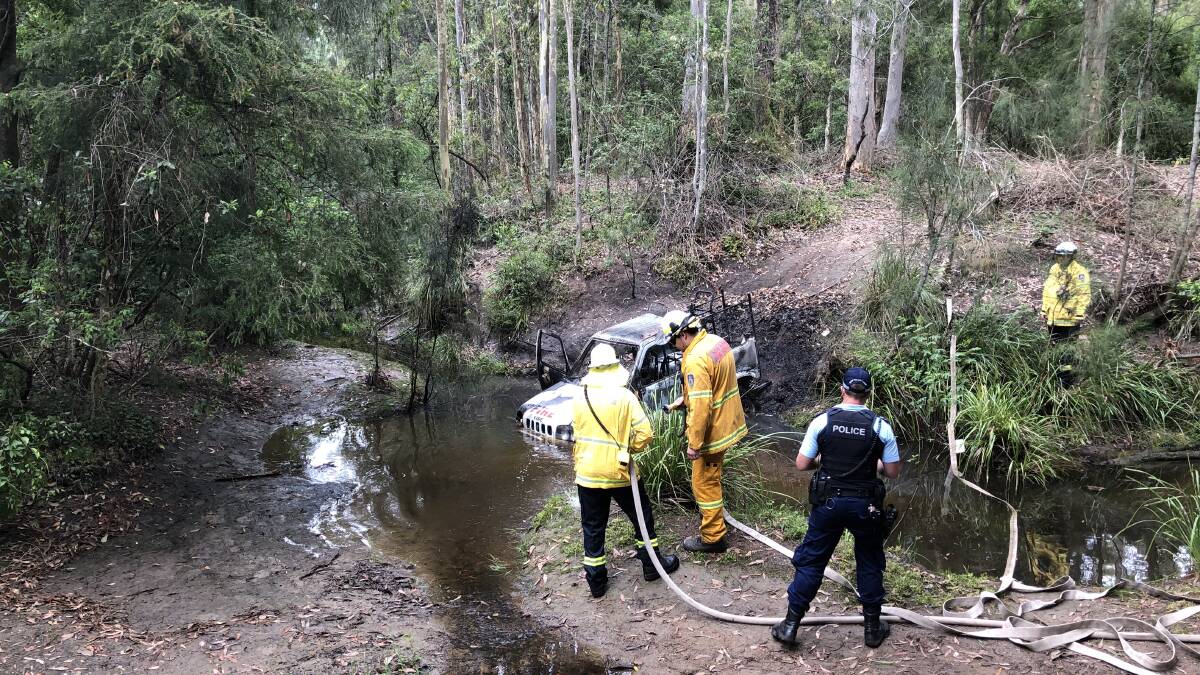 
BLAZE: NSW RFS crews extinguish the converted fire safety vehicle stolen from Nowra Speedway and found on fire Monday morning in a creek, just west of the Princes Highway. Photo: Contributed
