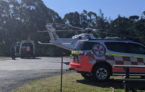 Ambulance crews prepare to transfer the injured woman to the Toll NSW Ambulance Rescue Helicopter at the Log Cabin, Tomerong. Photo: Stuart Thomson
