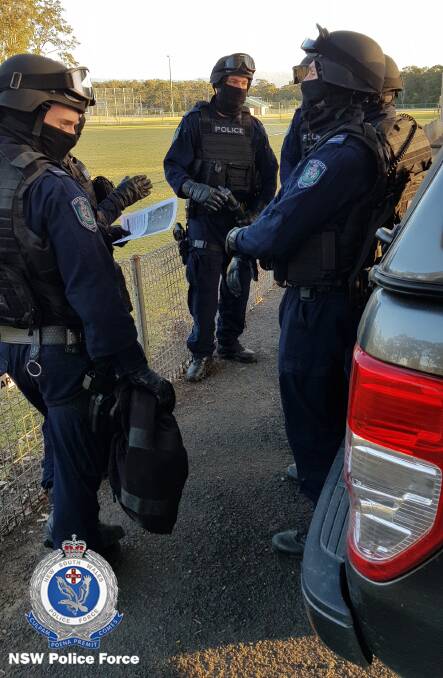 Officers from Strike Force Adnamira and Strike Force Raptor prepare to raid the Culburra Beach home. Photo: NSW Police Media