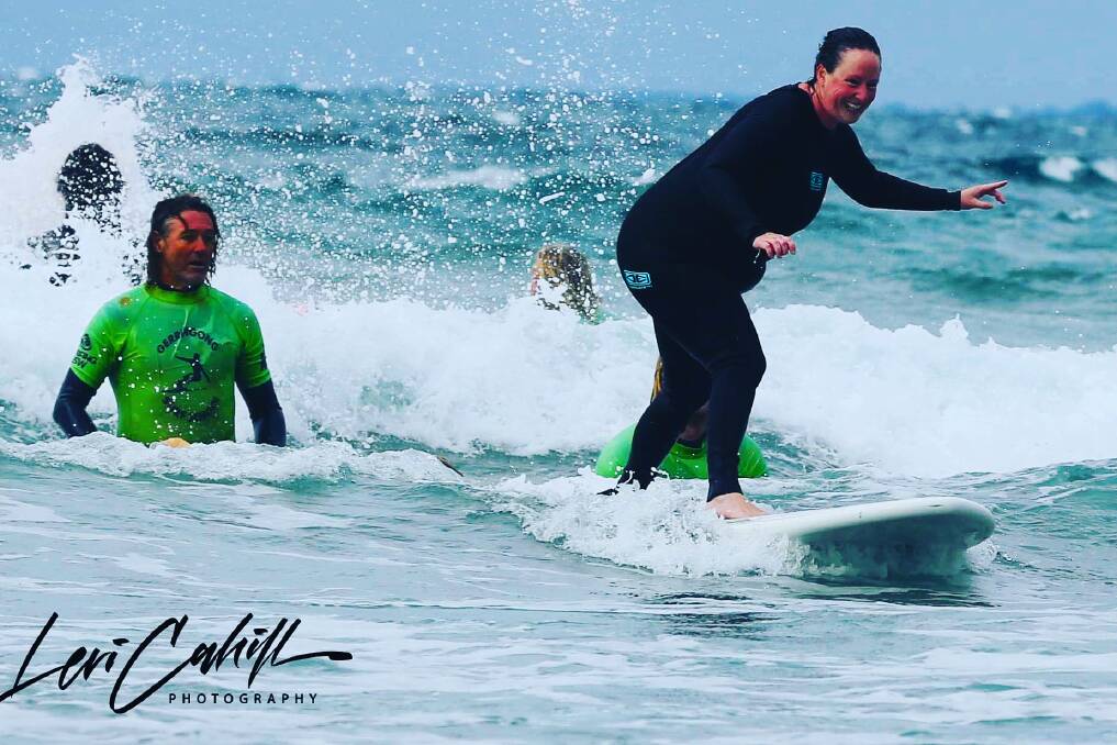 YES: The look on Suz Dendle's face says it all as she catches a wave as part of the Veteran Surf Project. Photo: Levi Cahill Photography