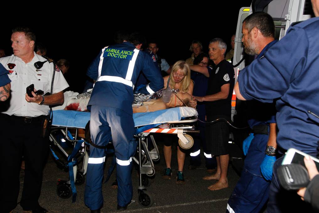 FLASHBACK: Bombo Beach on March 30, 2016. Injured surfer Brett Connellan lies on a stretcher with his mum Gail by his side, and surrounded by paramedics. Picture: Sylvia Liber 