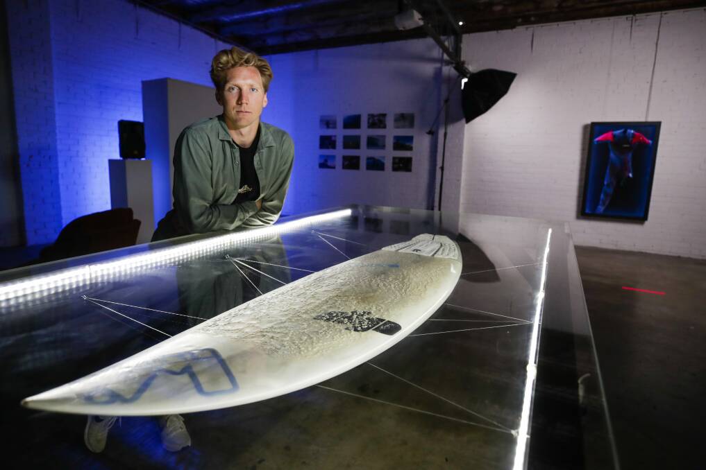 Shark attack survivor Brett Connellan with the surfboard he was using when attacked at Bombo beach in 2016. He and film maker Sam Tolhurst have created a movie about his attack and recovery that they hope to screen in 2022. Picture: Adam McLean