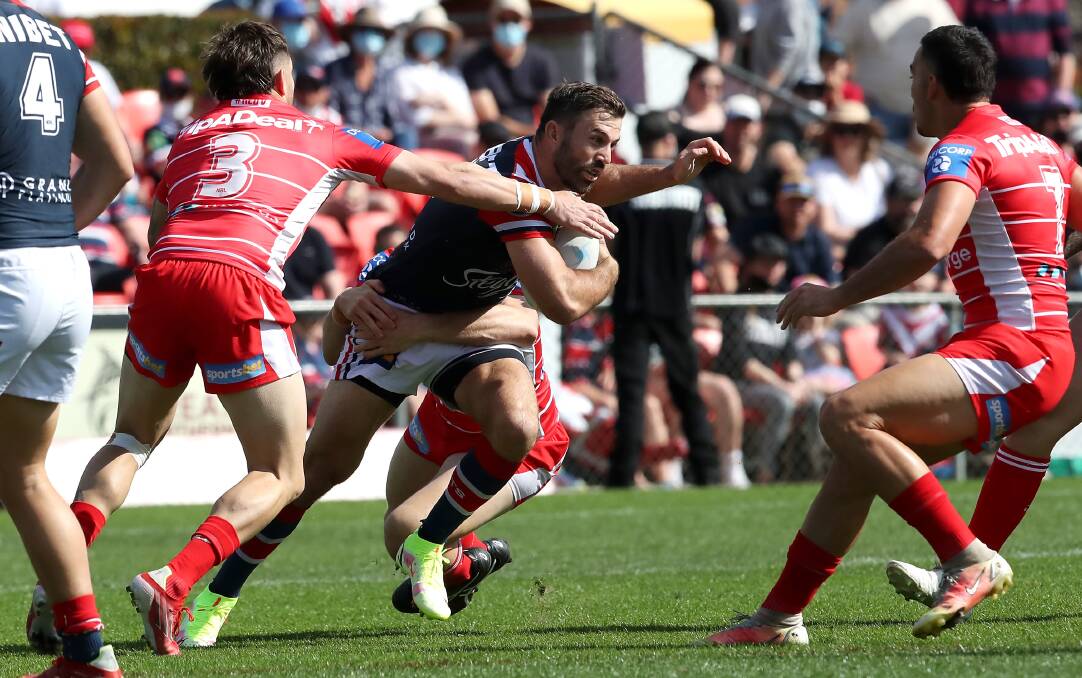 Sydney Roosters skipper James Tedesco tries to evade being tackle by Dragons opponents. Photo: Jono Searle