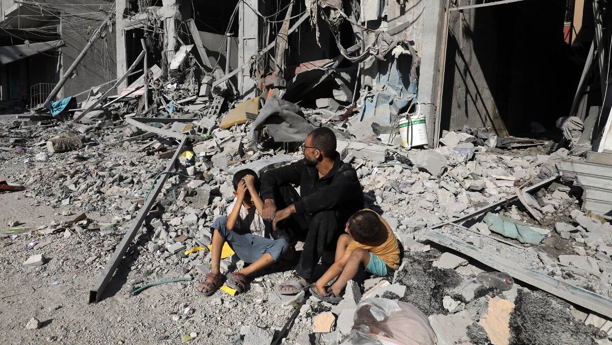 Palestinians search a house after an Israeli air strike, in the city of Rafah, south of the Gaza Strip, on October 12 2023.