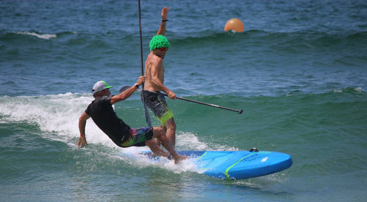 Man down: Sun and surf - with a little light-hearted fun and tom foolery pictured in the SUP relay - is the name of the game at the Merimbula Classic four-day surf event. 