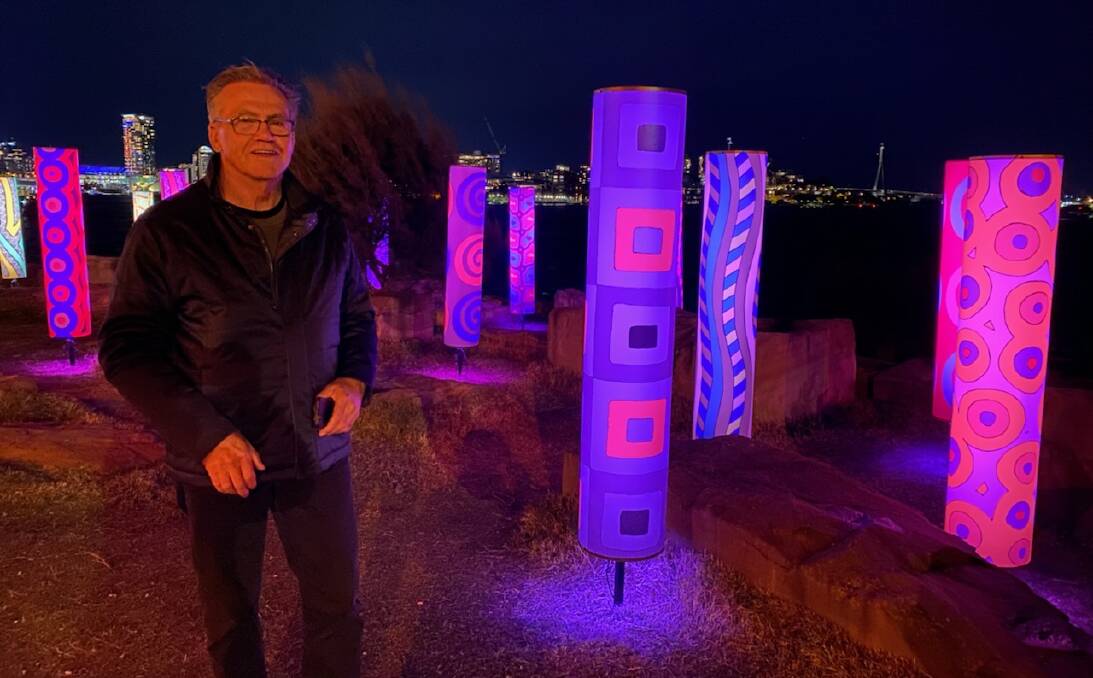Nowra artist and TAFE teacher Warwick Keen checks out the installation of his Indigenous tree-carving inspired pillars lit up as part of the Vivid Festival. Pictures: Adam Wright. 